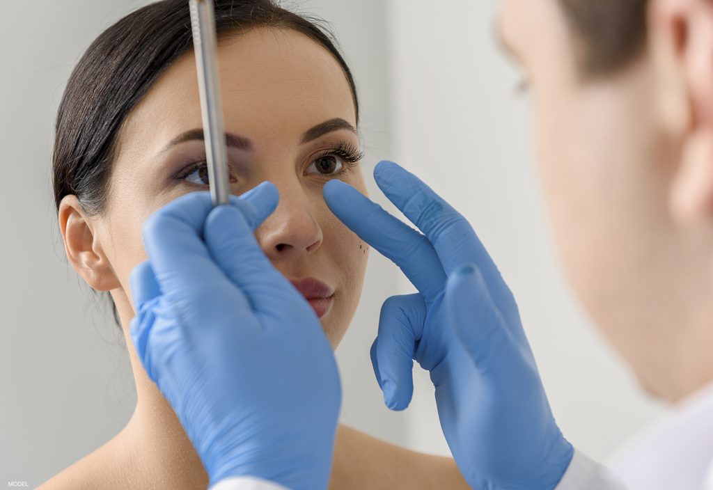 Doctor assessing a woman's nose